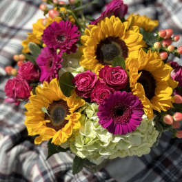 Bouquet of sunflowers, pink gerbera daisies, roses, and pale hydrangea