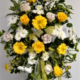 Yellow roses and white daisies in a standing floral spray
