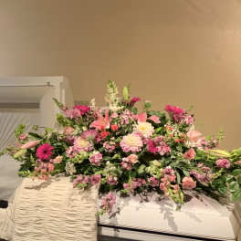 Large pink and white floral spray on a casket