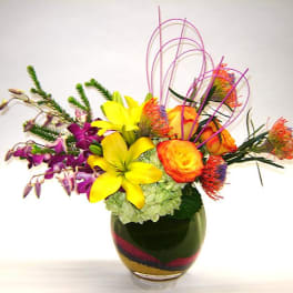 Bright mixed bouquet in a glass vase with yellow and orange blooms