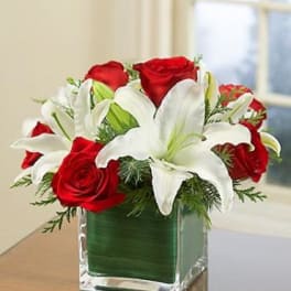 Red roses and white lilies in a clear square vase
