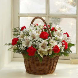 Red and white flowers arranged in a wicker basket