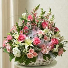 Basket arrangement of pink and white flowers with lilies and roses