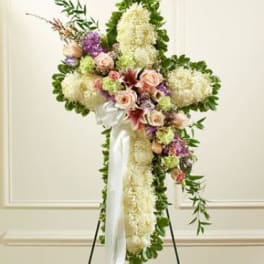 Standing floral cross with white and pastel flowers on an easel