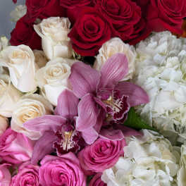 Bouquet of red, white, and pink roses with purple orchids and white hydrangeas
