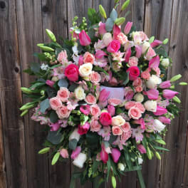 Large pink and white floral wreath on a stand