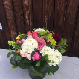 Pink and white mixed flower arrangement in a glass vase