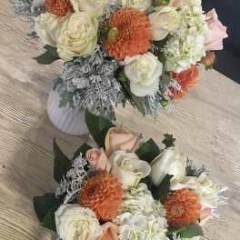Two floral bouquets with cream roses, orange blooms, and white hydrangeas