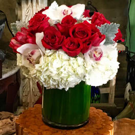 Red roses and white orchids arranged in a green vase