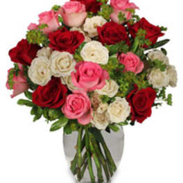 Bouquet of red, pink, and white roses in a clear glass vase