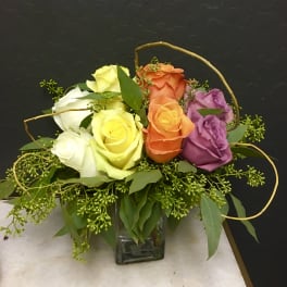 Colorful rose arrangement in a square glass vase