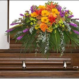 Colorful floral spray on a wooden casket