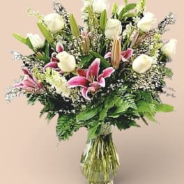 Bouquet of white roses and pink lilies in a clear glass vase