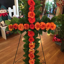 Cross-shaped rose arrangement on a stand with red and orange roses