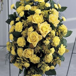 Yellow roses and carnations in a standing floral spray