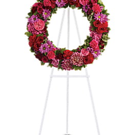 Pink and red floral wreath on a white easel