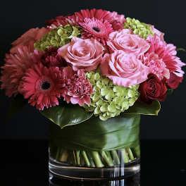 Pink roses and gerbera daisies in a glass vase