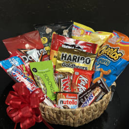 Gift basket filled with assorted snack bags and a red ribbon bow