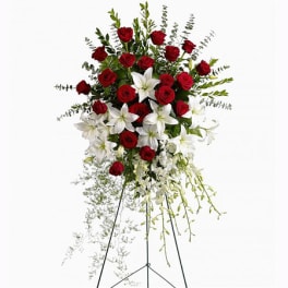 Standing floral spray of red roses and white lilies on an easel