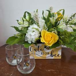 Yellow rose and white flowers in a decorative box with two bee-themed glasses