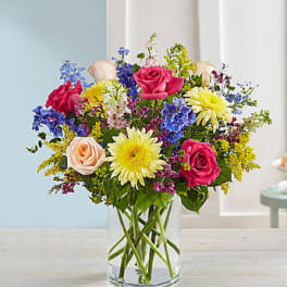 Mixed bouquet of roses and daisies in a clear glass vase