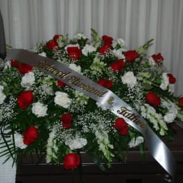 Large red and white rose funeral spray with a memorial ribbon