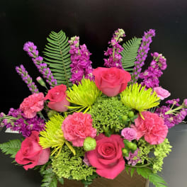 Bright pink roses and carnations in a low rectangular box