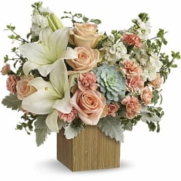 Peach roses and white lilies in a wooden cube vase