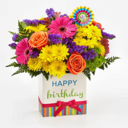 Bright mixed bouquet in a birthday gift box with a ribbon