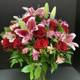 Bouquet of red roses and pink lilies in a glass vase