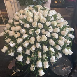 Large arrangement of white roses in a black container