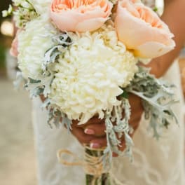 Bridal bouquet of peach roses and white blooms with silvery foliage