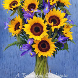 Bouquet of yellow sunflowers and purple irises in a glass vase