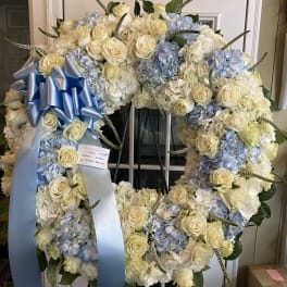 Large white and pale blue floral wreath with a blue ribbon bow