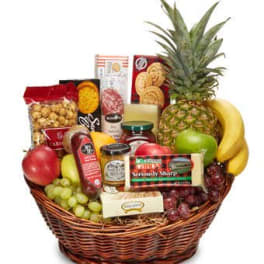 Fruit and snack gift basket with a pineapple, bananas, grapes, and packaged treats