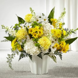 Yellow and white flower arrangement in a white vase