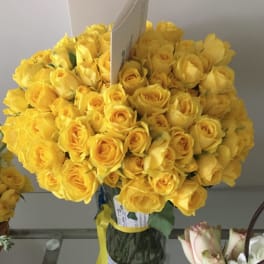 Bouquet of yellow roses in a glass vase with a ribbon