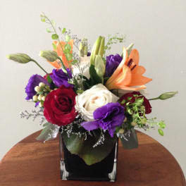 Mixed bouquet of roses and lilies in a black square vase