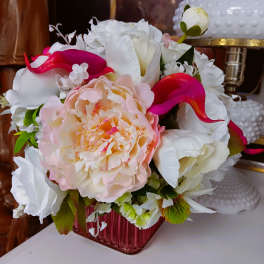 Bouquet of white and pink flowers in a pink glass vase