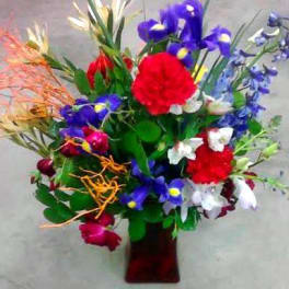 Colorful bouquet of mixed flowers in a red vase