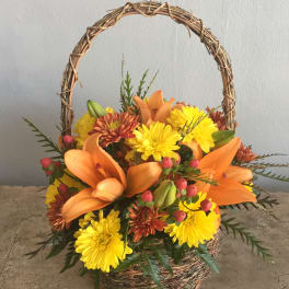 Basket arrangement with orange lilies and yellow chrysanthemums