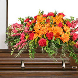 Bright floral arrangement on a wooden casket