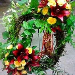 Heart-shaped floral wreath with red lilies and yellow roses