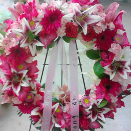 Pink and white floral wreath with ribbon on a stand
