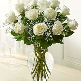 White roses arranged in a clear glass vase