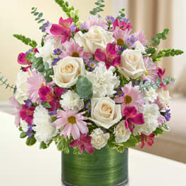Pink and white mixed flower arrangement in a green vase