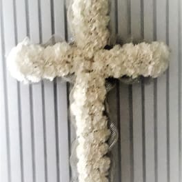 White floral cross on a ribbed gray background