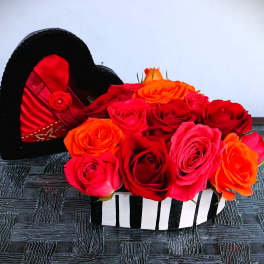 Heart-shaped box filled with red, pink, and orange roses