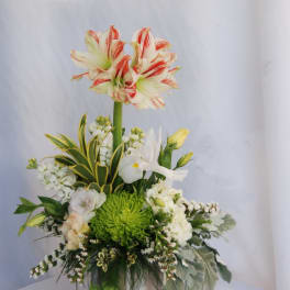 Tall floral arrangement with red-striped white lilies in a metal vase