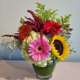 Colorful mixed bouquet in a glass vase with gerbera daisies and hydrangea